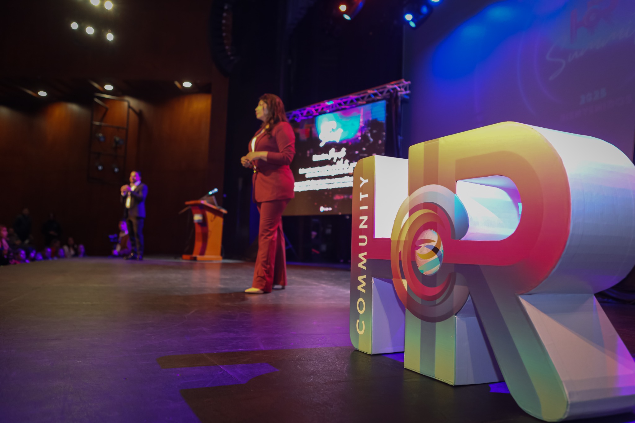 Escenario de un encuentro con las letras de HR Community en los colores de la marca